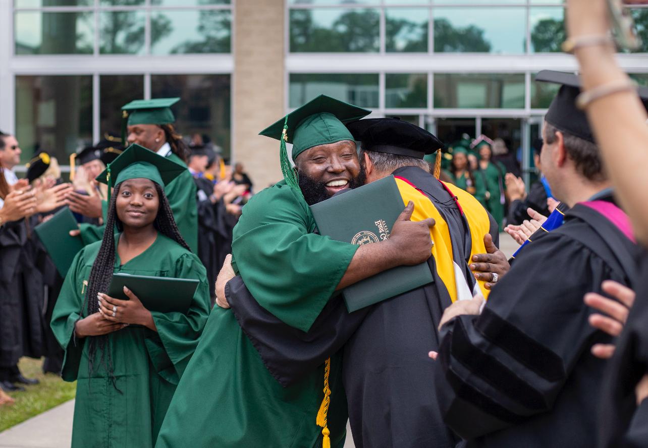 graduate hugs professor after receiving his degree